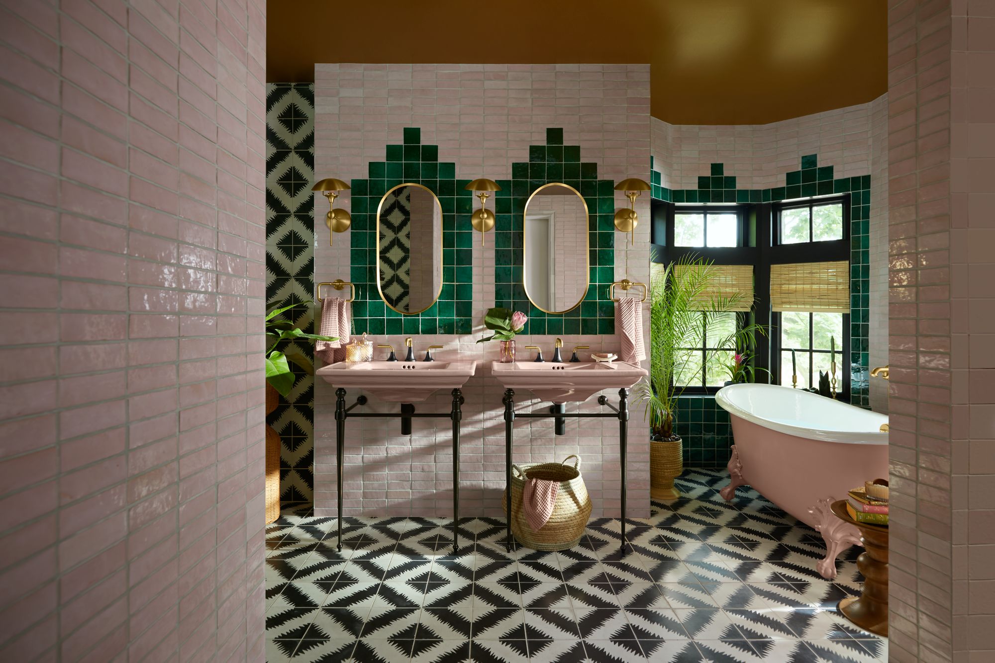 Statement bathroom with emerald tile, brass fittings and twin pink vanities
